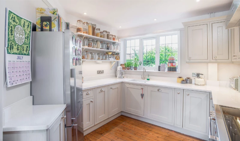 Contemporary white space saving kitchen with wooden floor